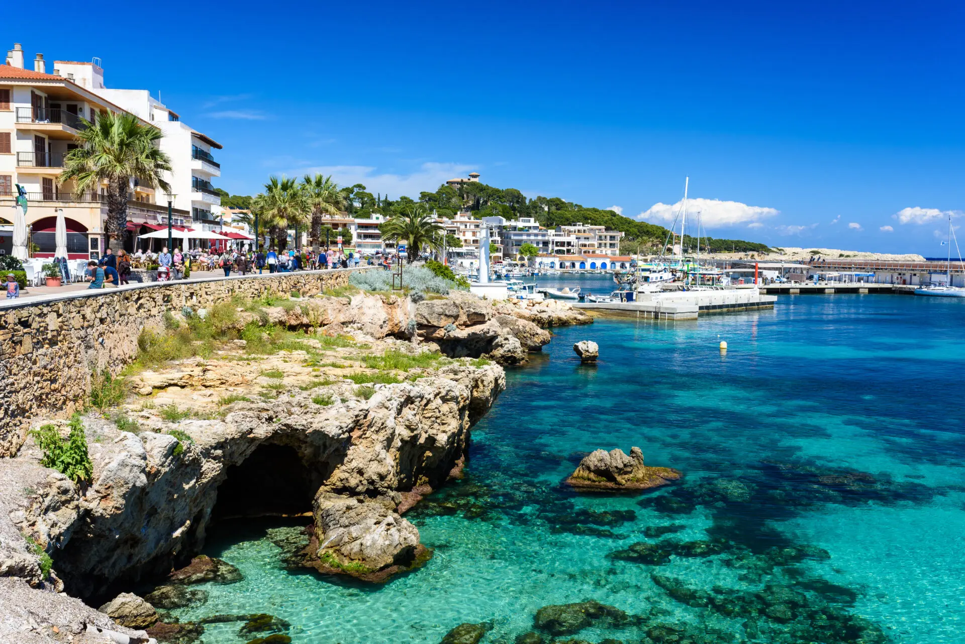 Cala Ratjada waterfront and harbour beneath a clear blue sky