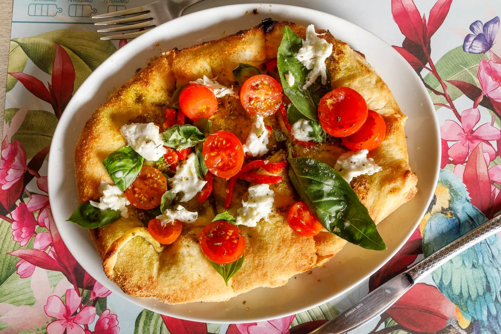 Pizza with tomatoes, basil and cheese at ENCANTO