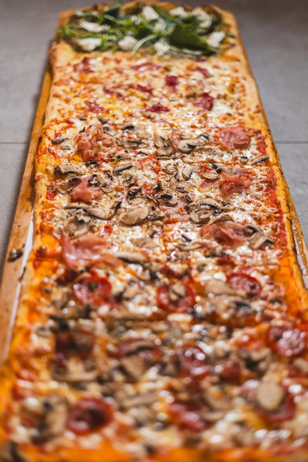 Pizza by the metre with assorted toppings at ENCANTO