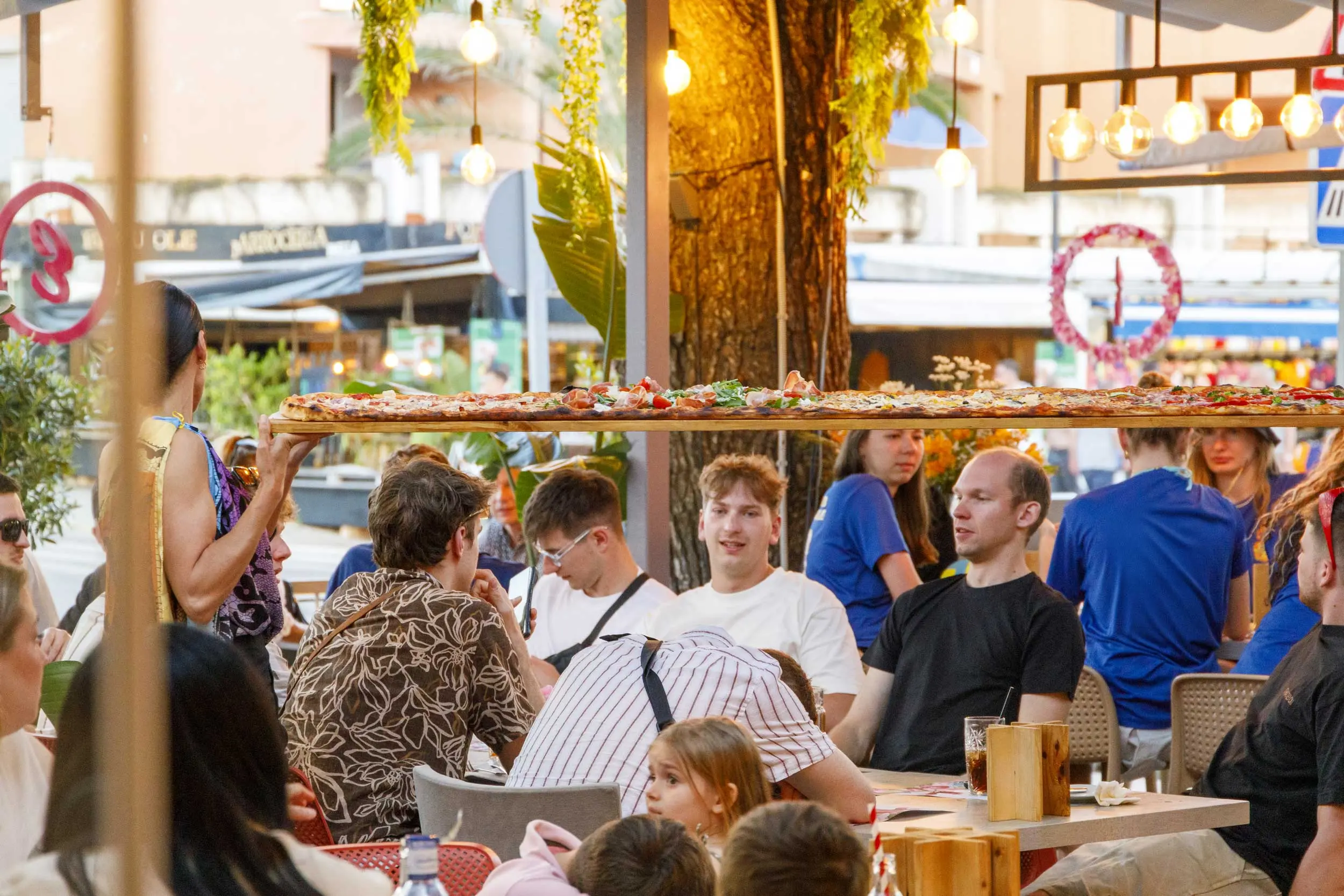 Long pizza carried across the ENCANTO terrace