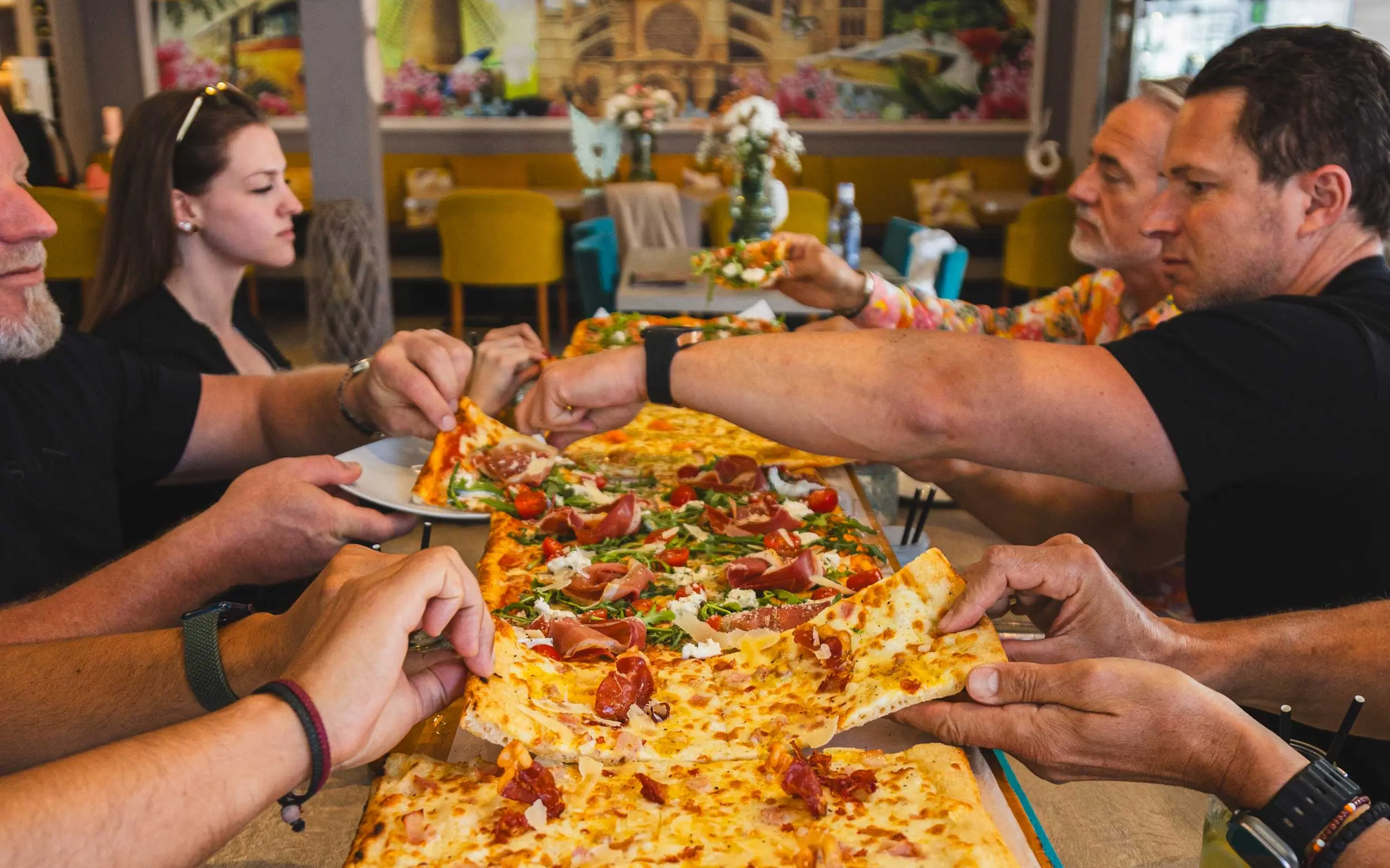 Guests sharing a long pizza at ENCANTO