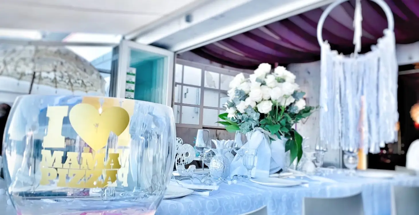 Table set with flowers and a Mama Pizza glass