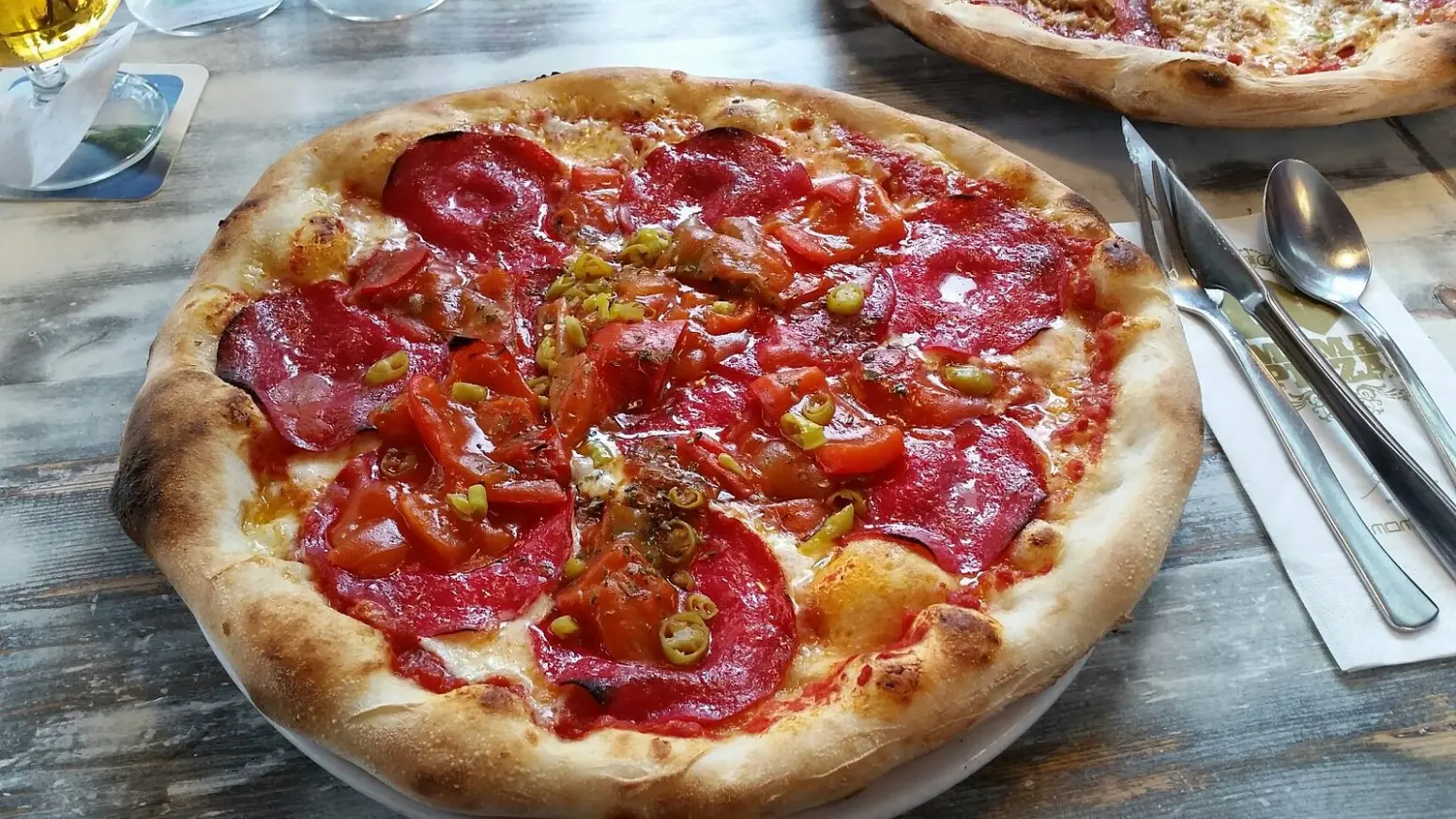 Pizza topped with salami and tomatoes
