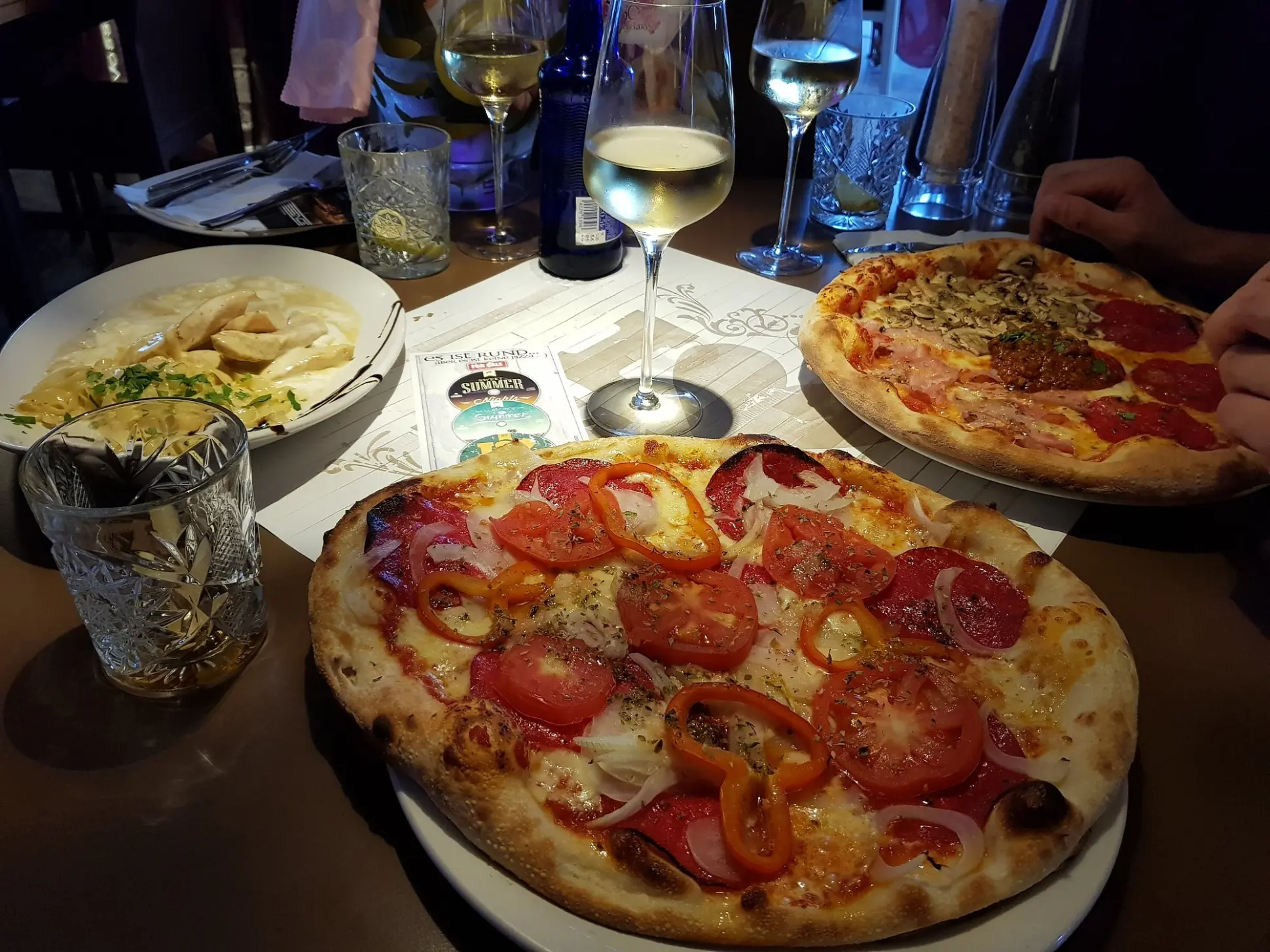 Pizza and other dishes on an evening table