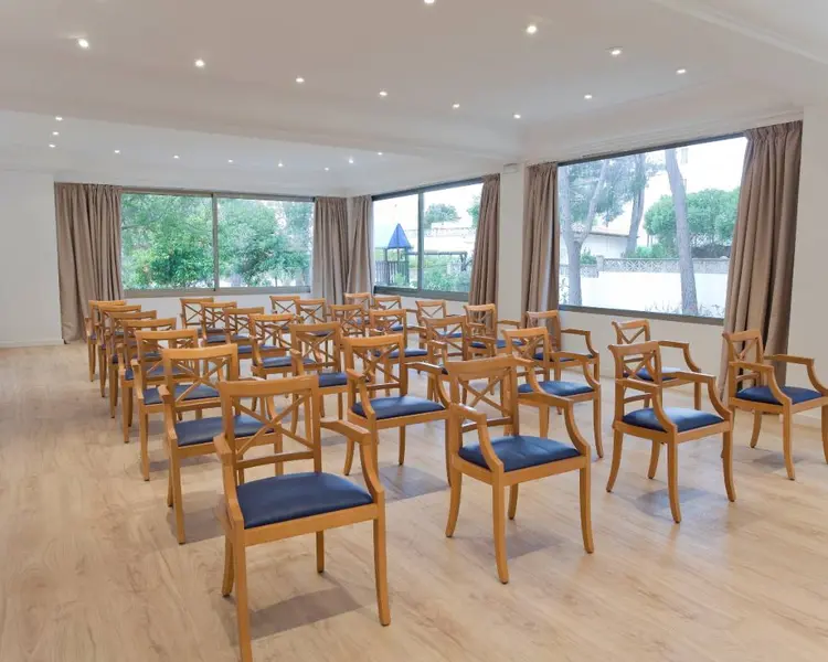Event hall arranged with tables and chairs at Flacalco Hotels