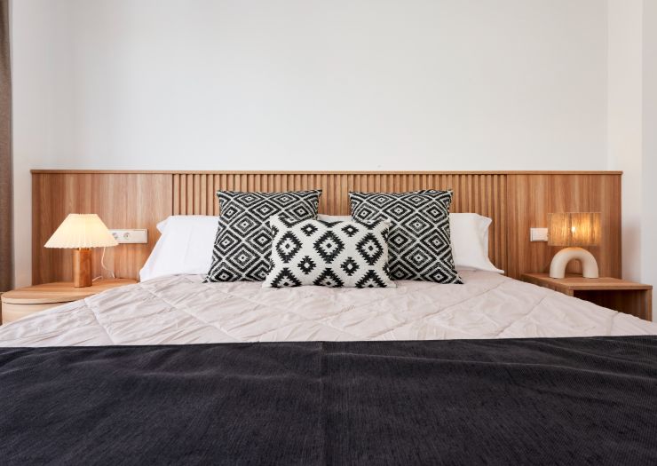 Apartment double bed with wood paneling and patterned cushions
