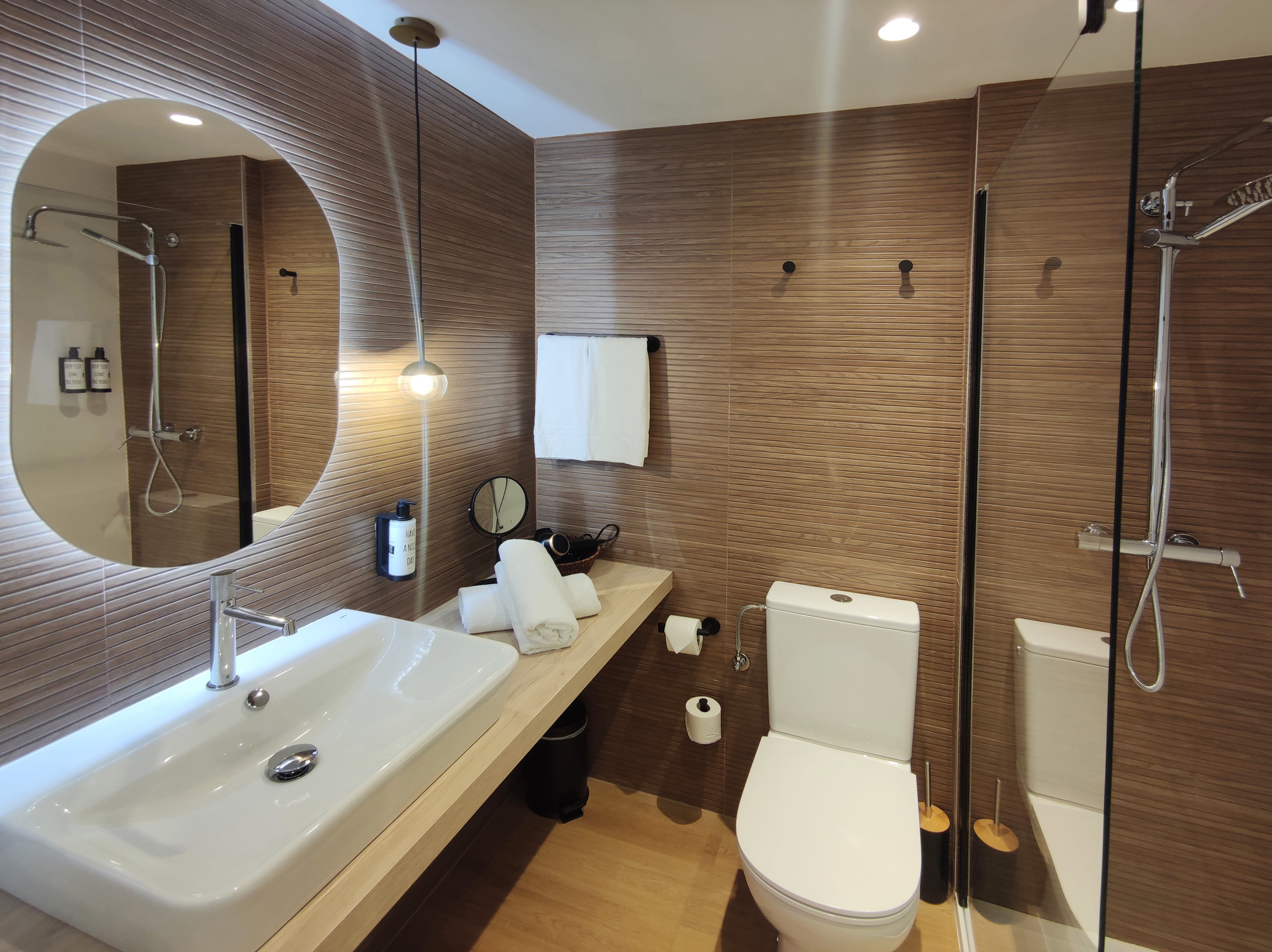 Modern bathroom with a walk-in shower and round mirror
